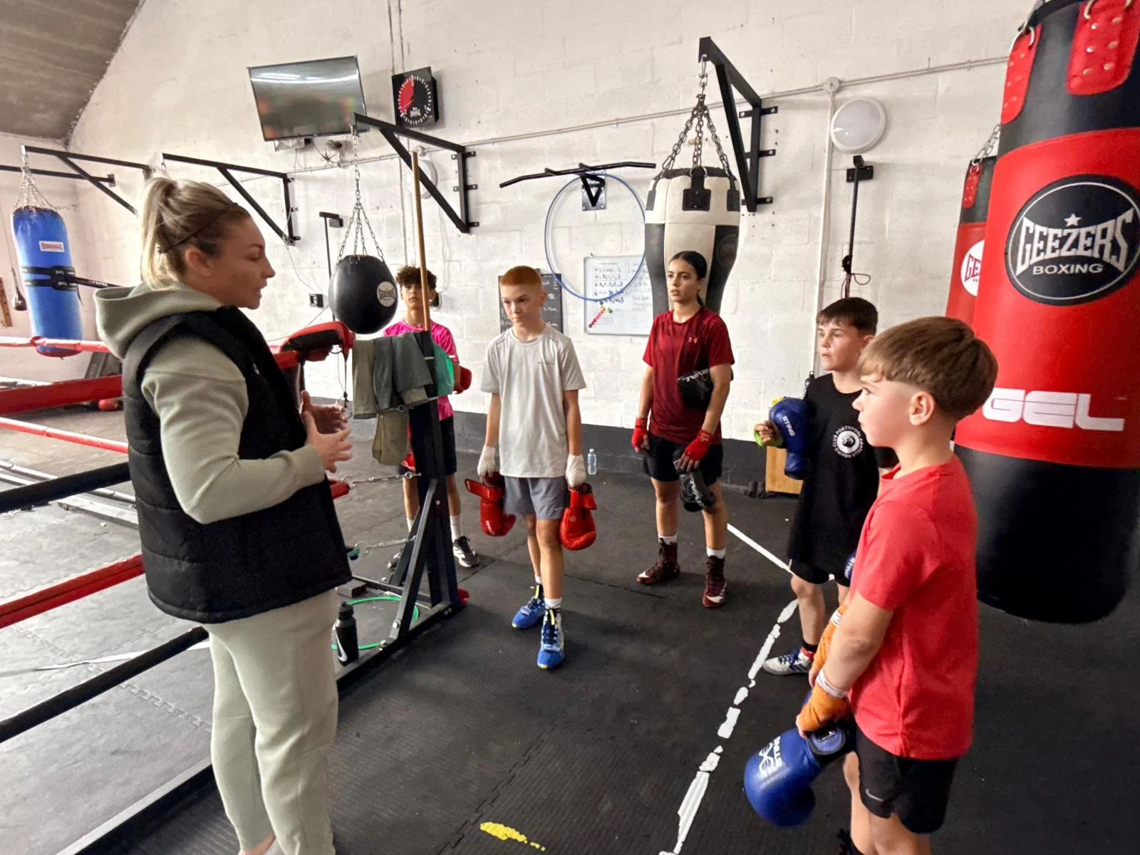 Lauren Price MBE speaking with young boxers at the gym